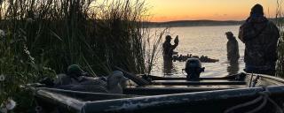 Duck hunters with decoys and a boat