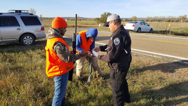 Warden checking hunting licenses in the field
