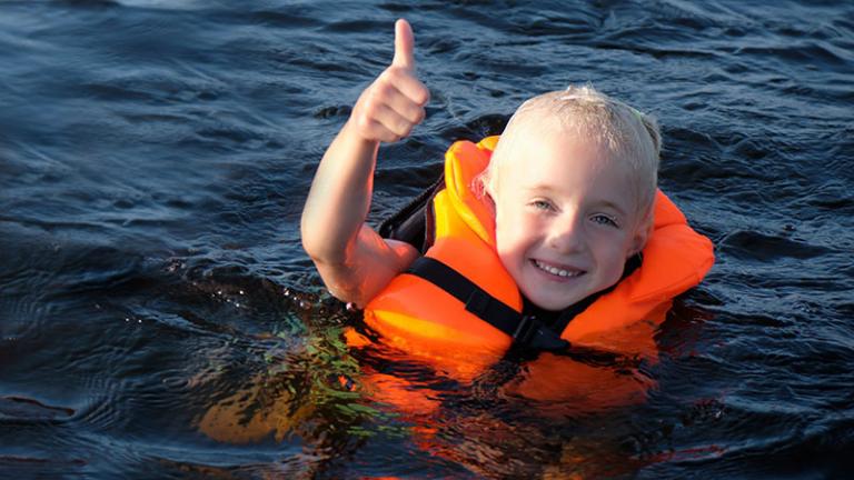 Kid wearing a life jacket in the water
