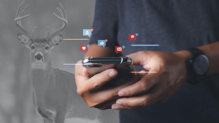 Deer in background with social media icons hovering over person typing on phone.