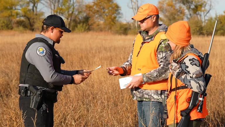 Warden checking hunter's license