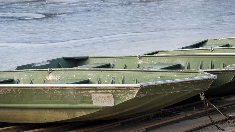 Johnboats docked. Ice in water behind them.
