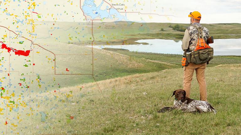 Hunter with dog in grasslands with map overlay on image.