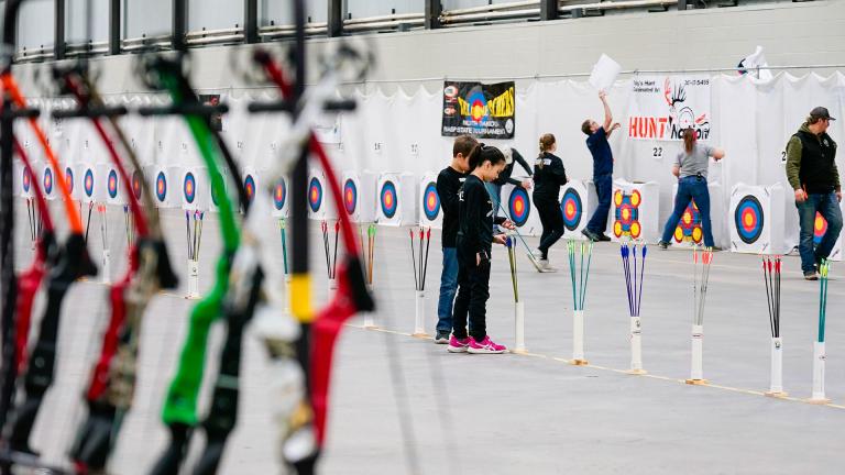 Bows in front, kids participating in a NASP tournament in background.