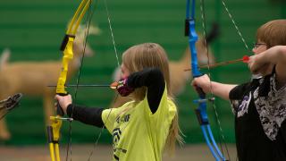 Students shooting at targets with bows