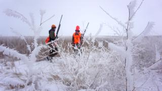 Hunters in background with frost covered bushes in front