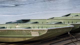 Johnboats docked. Ice in water behind them.