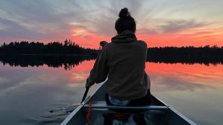 Woman canoeing at sunset