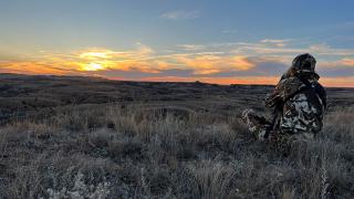 Person in badlands hunting at sunrise