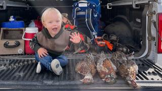 Son waving from a truck tailgate with three harvested pheasants beside him
