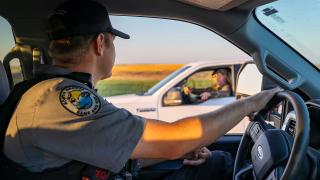 Warden in a truck talking to a passerby 